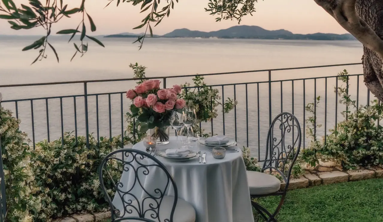 Romantic seaside dining beneath olive trees, with candlelight and ocean views creating an unforgettable evening.