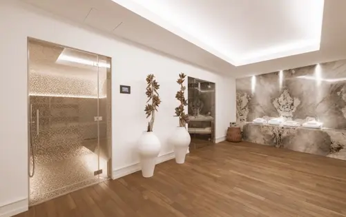 Contemporary wellness space featuring elegant natural stone, warm lighting, and serene design for ultimate relaxation.