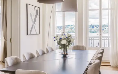 Refined dining space filled with natural light, blending contemporary elegance with serene waterfront views.