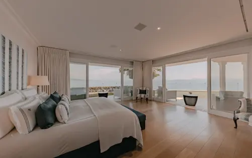 Elegant bedroom with floor-to-ceiling windows and panoramic sea views.