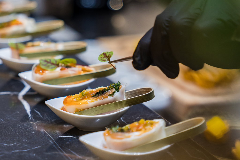 A gourmet chef delicately garnishes elegant appetizers, blending color, texture, and artistry for an unforgettable fine dining experience.